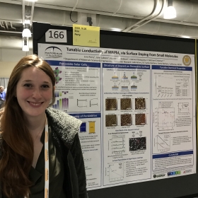 Erin poses by her poster on doping MAPbI3 to control conductivity
